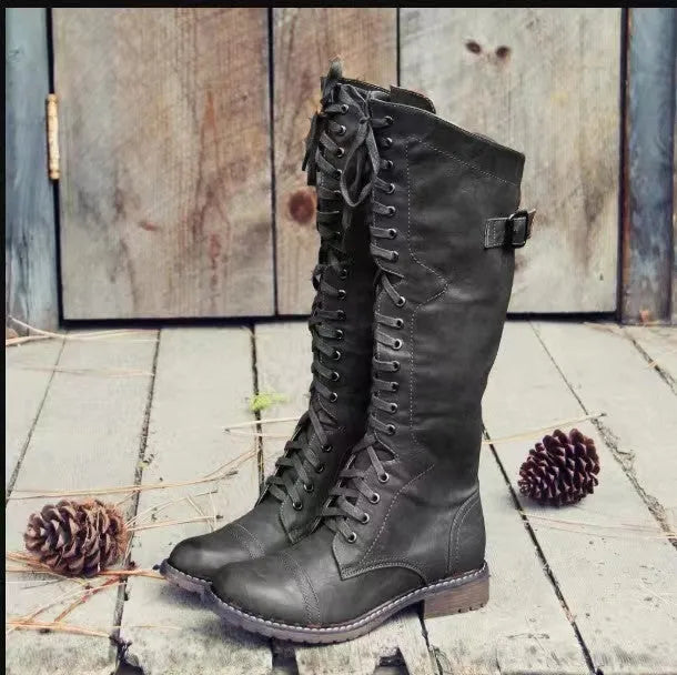 Women's black chunky heel high leg boot with a round toe and rubber sole.