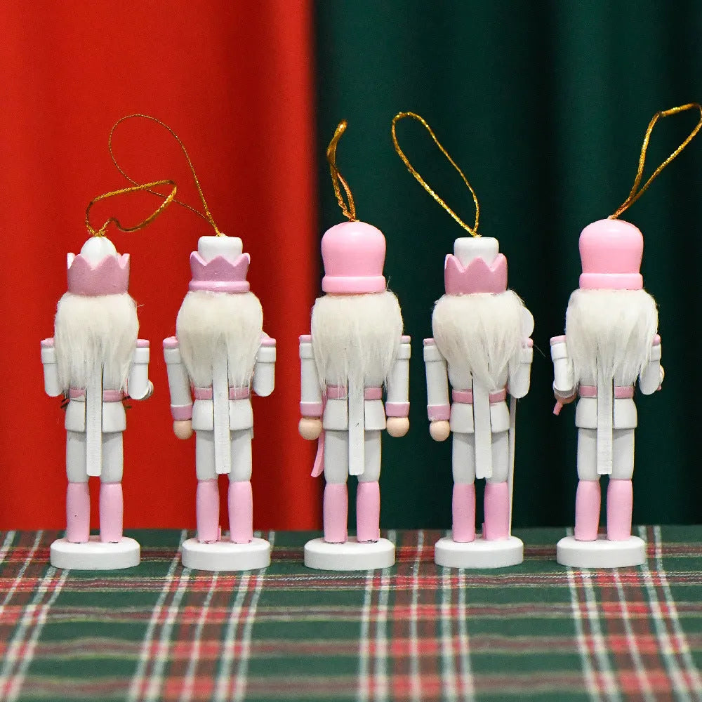 Five pink wooden nutcracker soldier puppets each 13cm tall arranged as Christmas garland ornaments