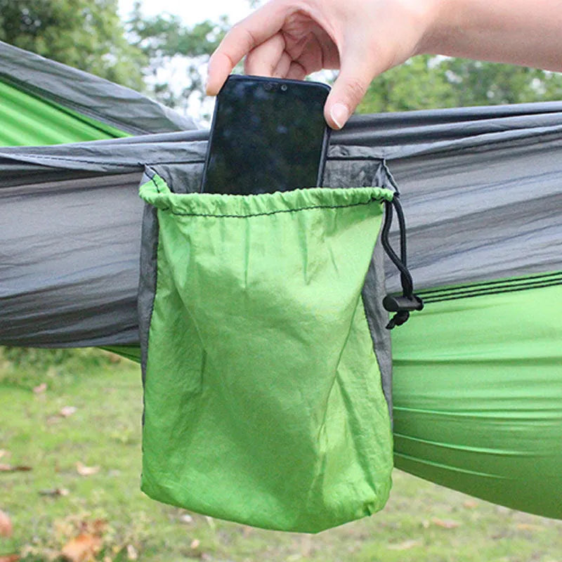 Blue parachute nylon outdoor camping hammock hung between two trees.