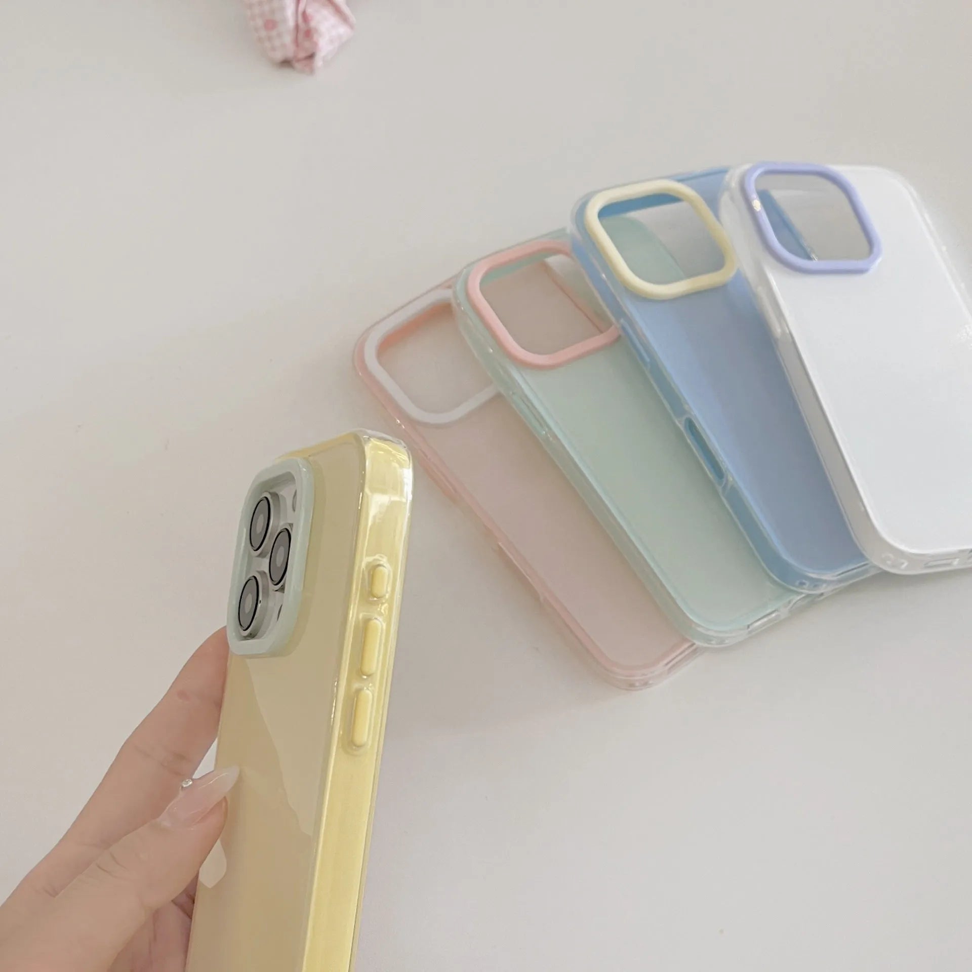 Simple solid colour jelly TPU phone case for iPhone, shown in blue, white and yellow.