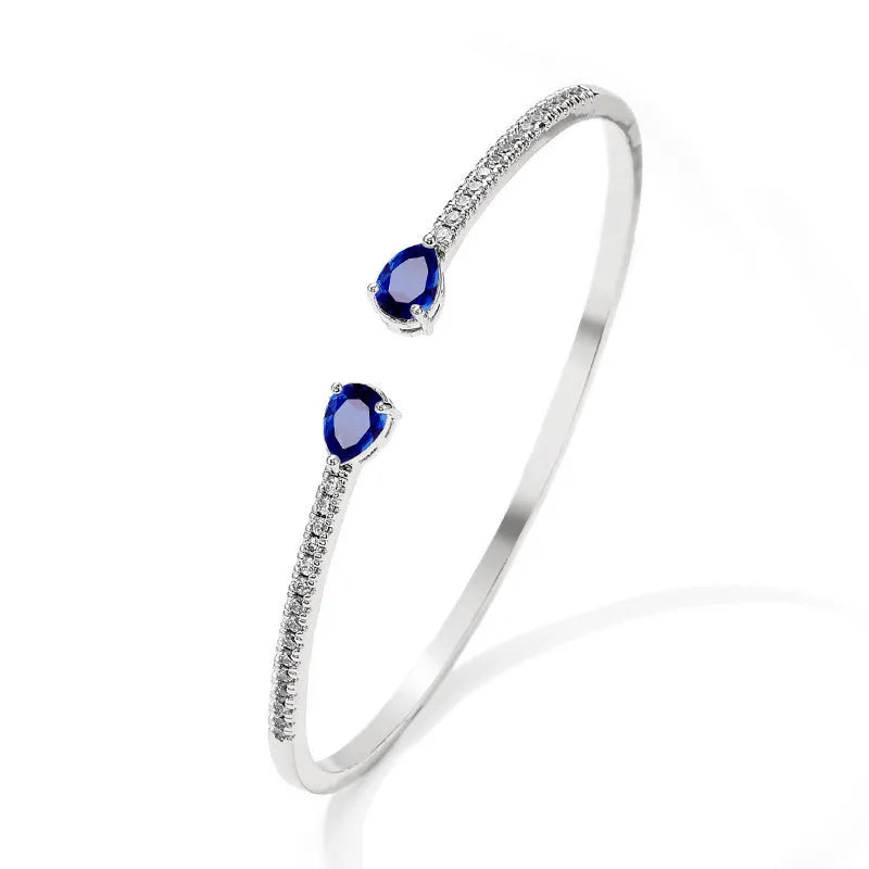 Copper bracelet with inlaid zircon decoration in blue colour on wrist