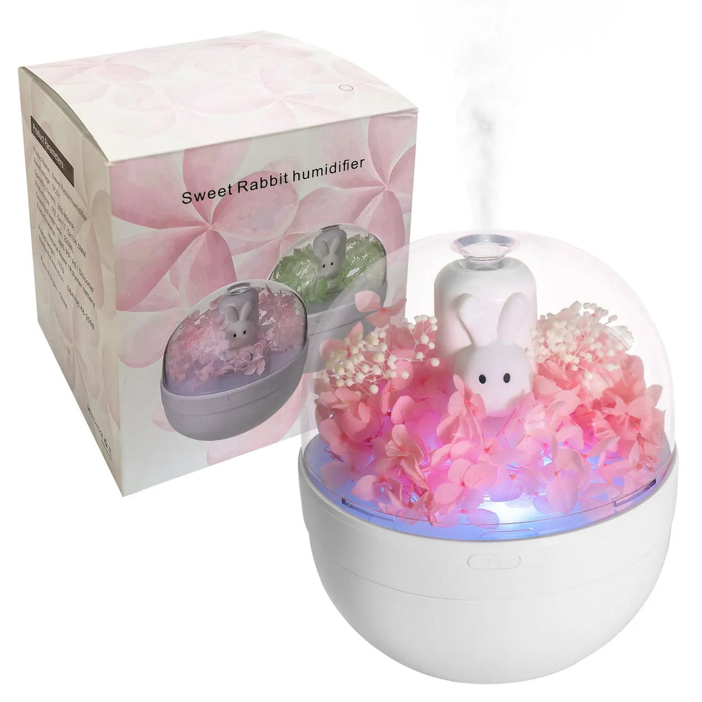 Pink rabbit-shaped aromatherapy humidifier with preserved flower decoration on bedside table