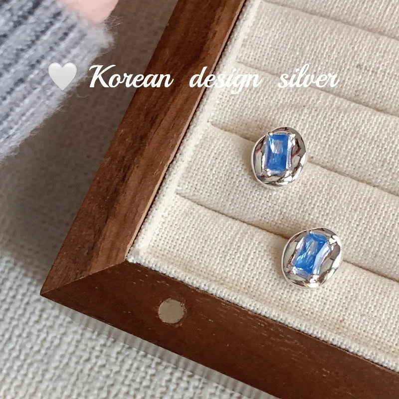 S925 sterling silver oval earrings with heart-wrapped blue diamond design in silver colour