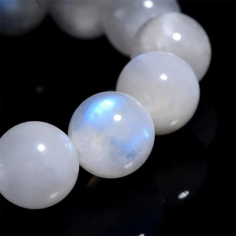 Natural blue moonlight round moonstone bead bracelet on a white background showing polished gemstone beads.