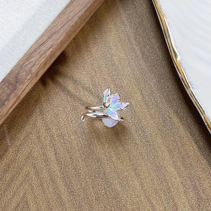 Adjustable copper insect ring with dripping oil finish in one of three colours on a hand.