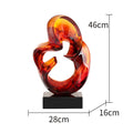 A transparent resin sculpture ornament in a modern style, shown in blue and orange red colour options.