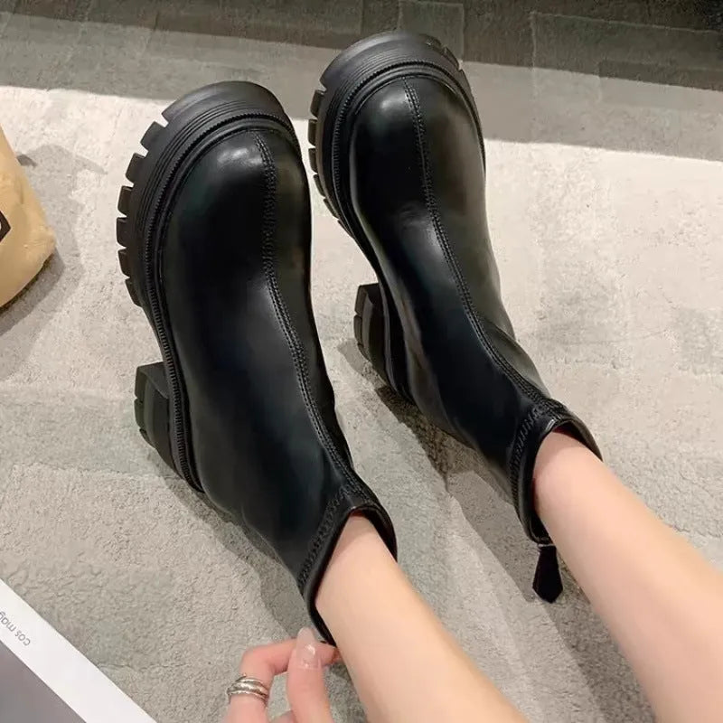 White platform ankle boots for women with thick foam rubber sole, mid-calf shaft, square heel, round toe, and back zipper.