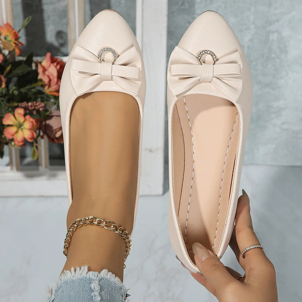 Women's beige flat casual shoes with a bowknot and shallow mouth design on a white background.