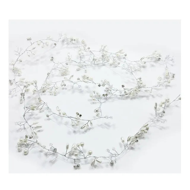 Close-up of a silver bride's hair band with pearls and crystals on a wired base.