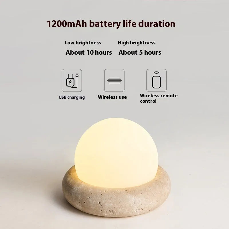 Cream coloured bedside night lamp with remote control on wooden table