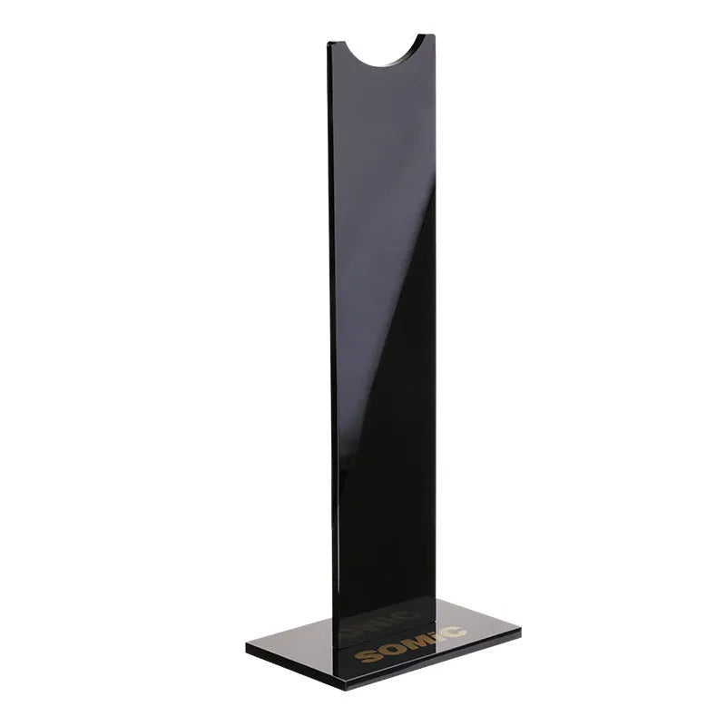 Pink and black detachable headphone stand for gaming headsets on a desk