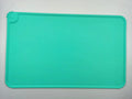 Silicone pet placemat under dog food and water bowls in a grey colour on a wooden floor.
