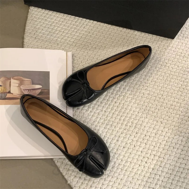 Women's black split-toe flat pumps with a round toe and slip-on oversleeve design.