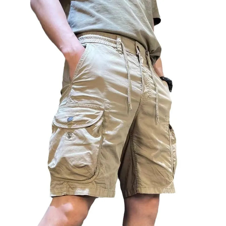 A pair of loose-fitting straight leg casual overalls in khaki colour with multiple pockets, shown laid flat.