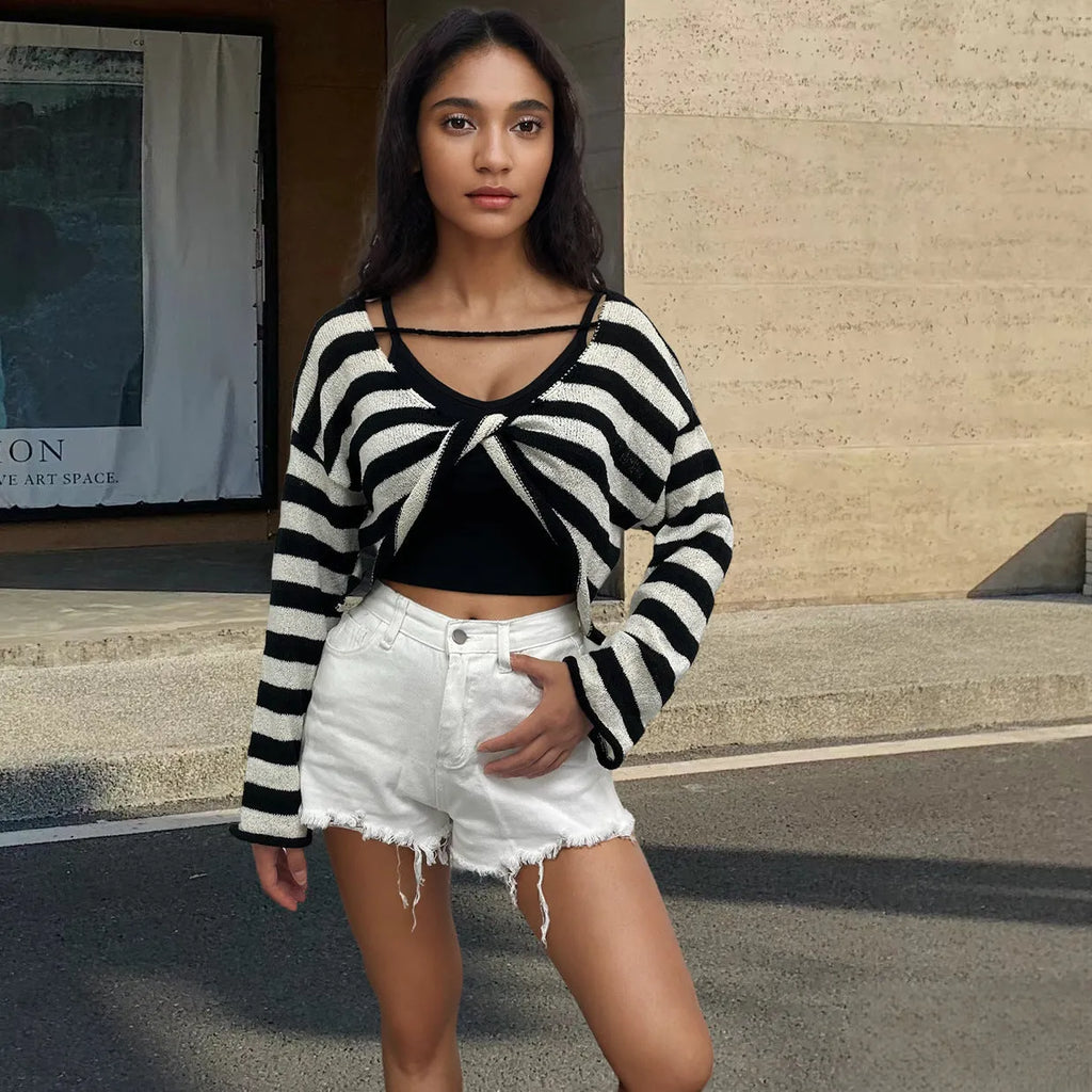 Woman wearing a striped long-sleeved sweater with an exposed navel, showcasing front and back wearable design in mercerised cotton.
