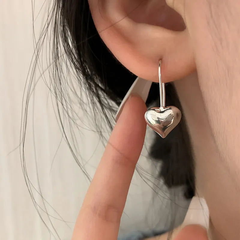 Silver-coloured heart-shaped earrings with three-dimensional glossy finish and Korean-style design