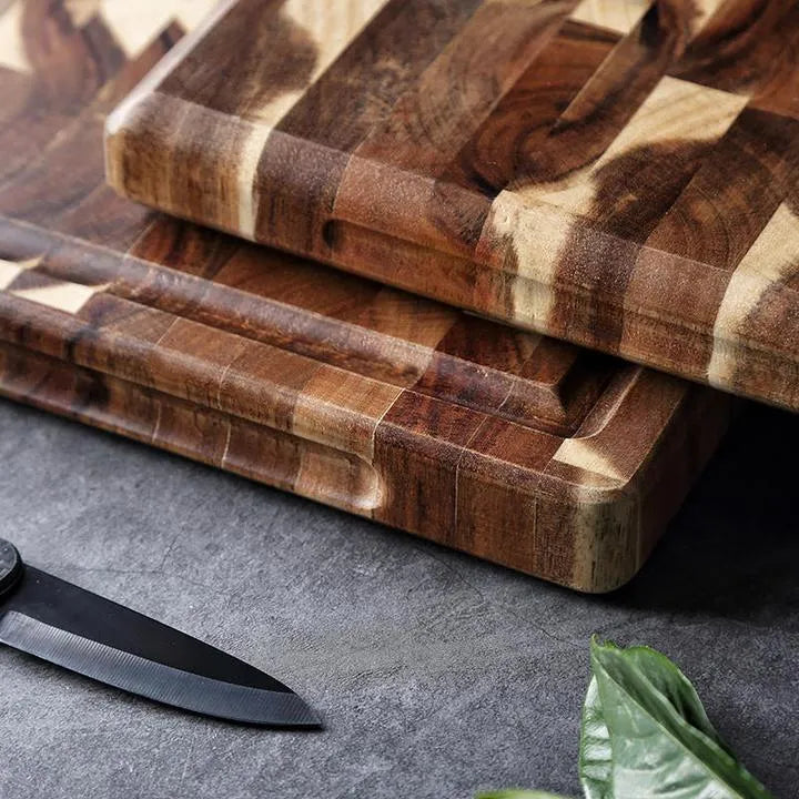 Brown parquet pattern solid acacia wood chopping board on a kitchen counter.