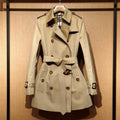 Khaki double-breasted polyester trench coat for women with flight sleeves on a hanger.
