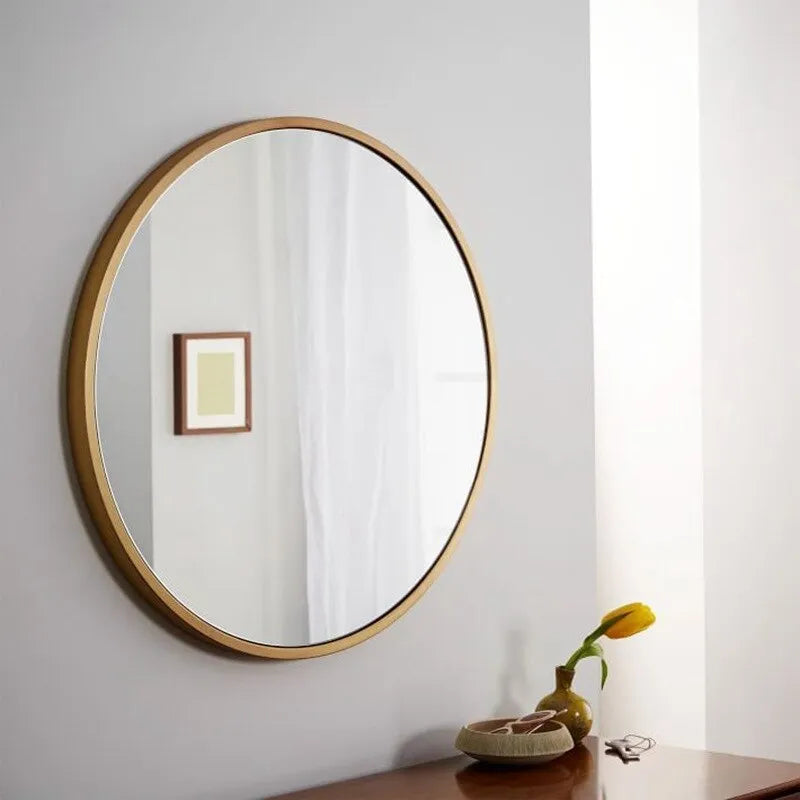 Round metal wall mirror in black finish, shown on a bathroom wall.