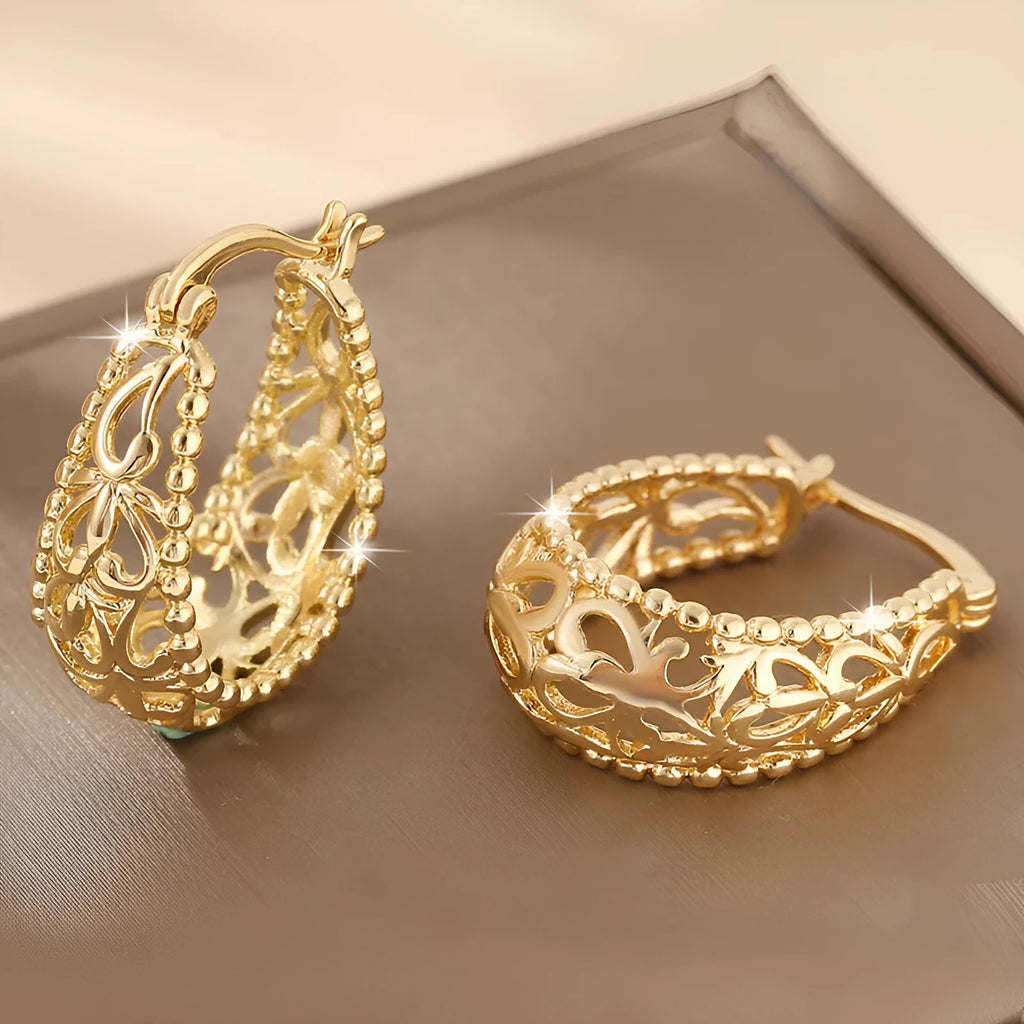Gold copper geometric hollowed-out large earrings with round shape on neutral background