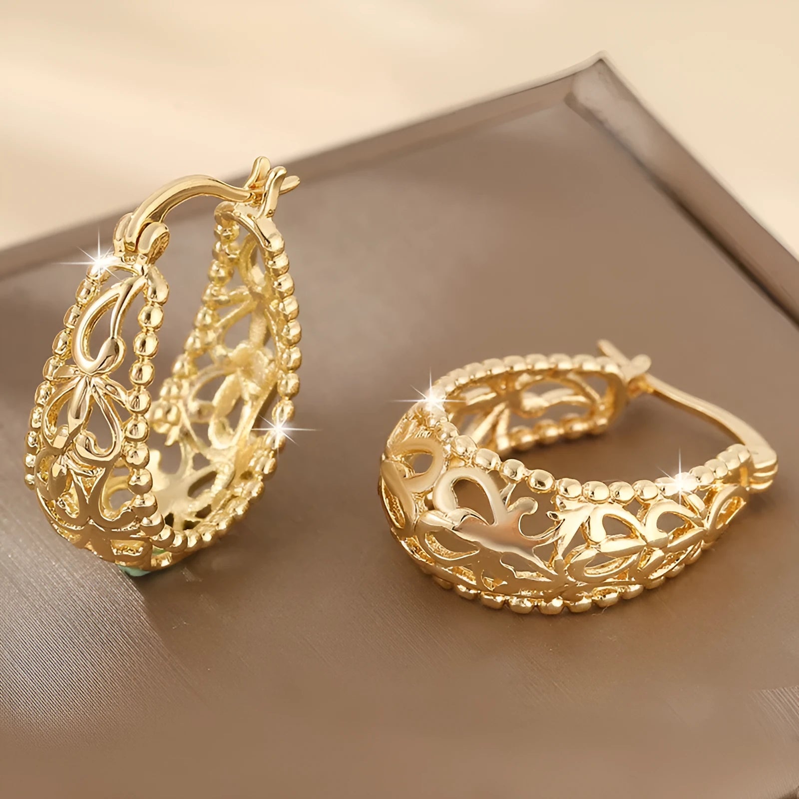 Gold copper geometric hollowed-out large earrings with round shape on neutral background