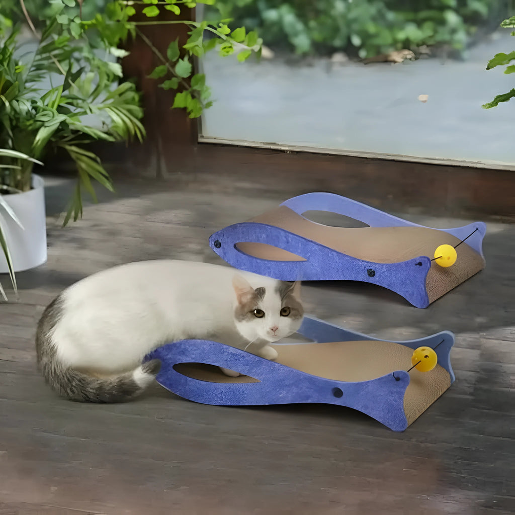 Blue fish-shaped cat scratcher lounge with corrugated cardboard surface and attached bell ball toy
