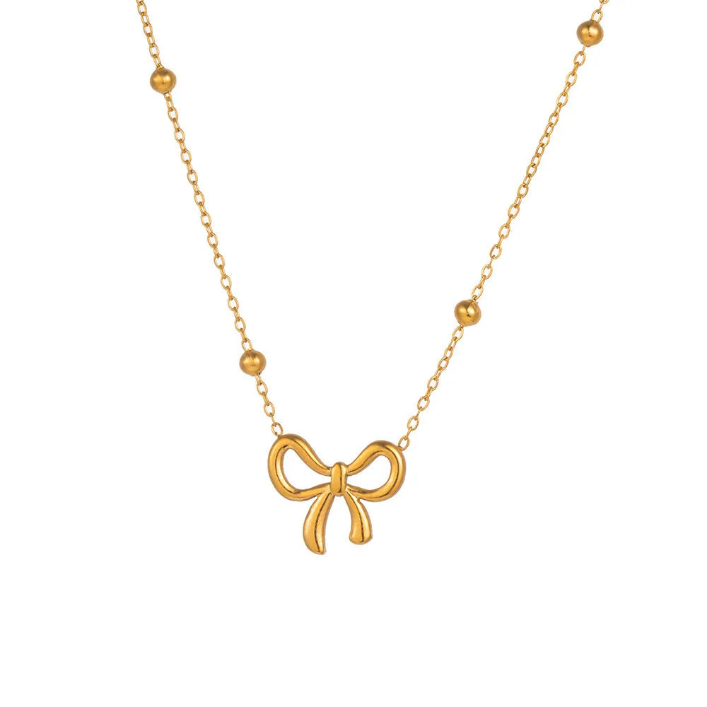 Gold electroplated titanium steel bow necklace on a cross chain, adjustable length.