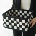 Checkerboard patterned grey felt storage basket with folded sides, shown empty.