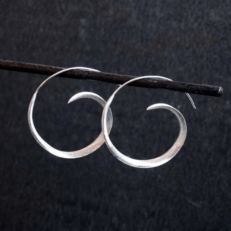 Gold alloy geometric round spiral leaf ear studs with electroplated finish on white background