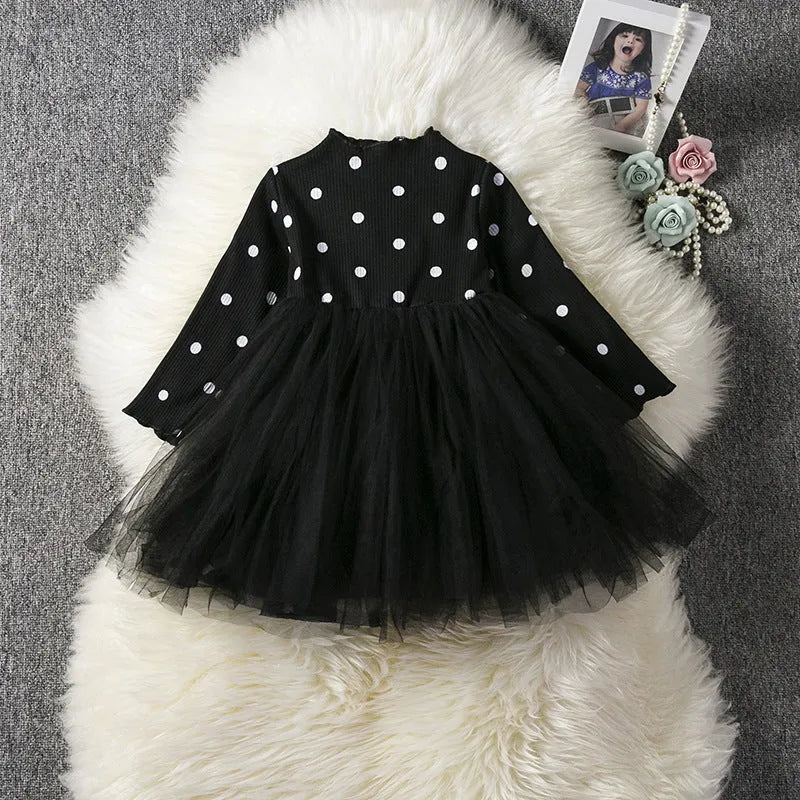 Baby girl wearing a long sleeve white lace tutu dress for a christening or birthday party.