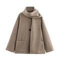 Women's long black overcoat with artificial fur collar, showing extended length and street fashion style.