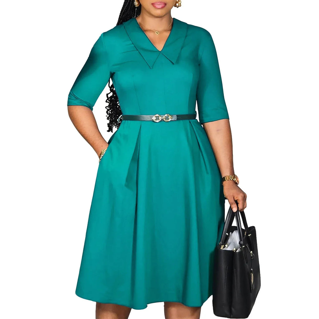 A woman wearing a solid colour African dress with half sleeves and a high waist, featuring a matching belt.