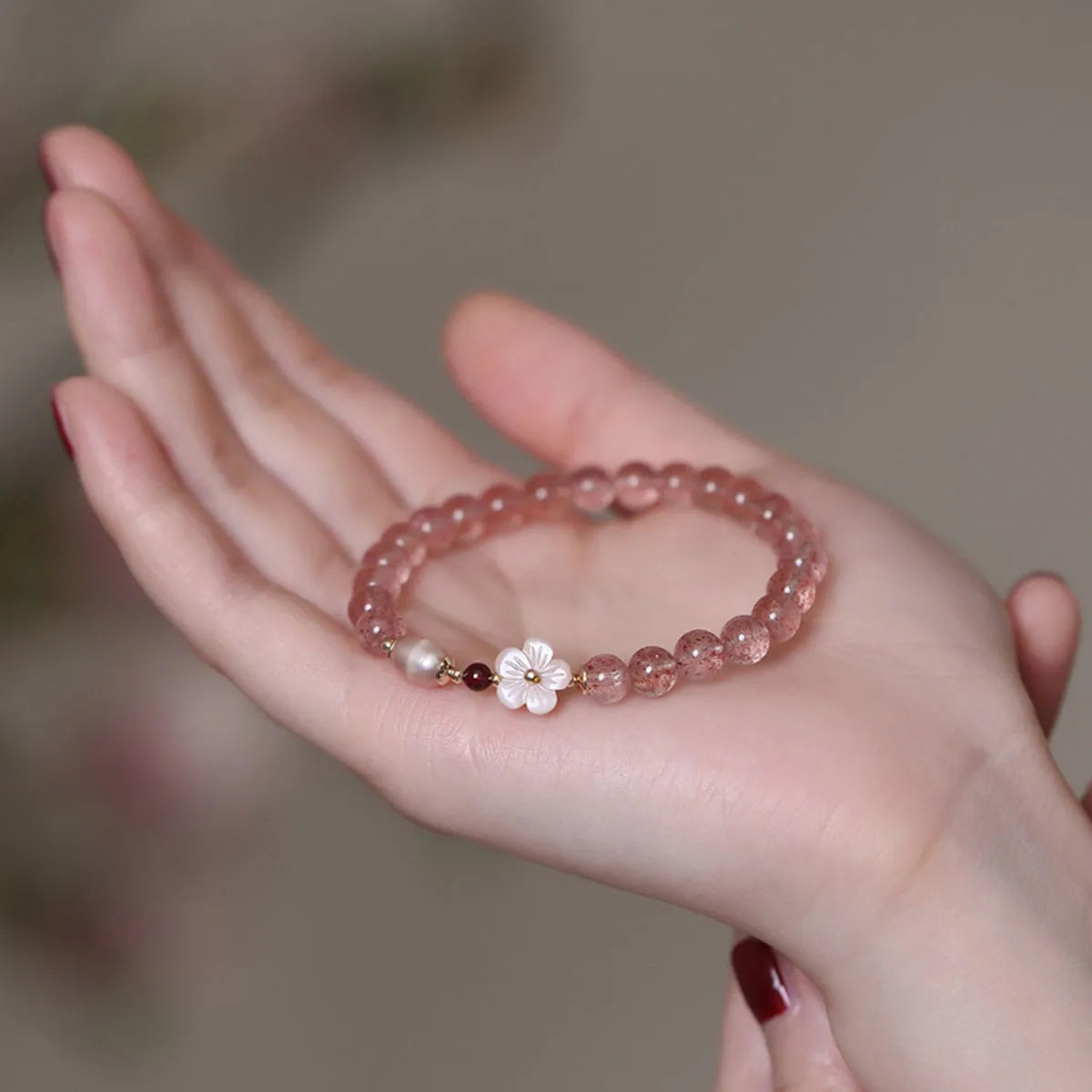 Strawberry quartz crystal bracelet with flower-shaped design on adjustable band for women
