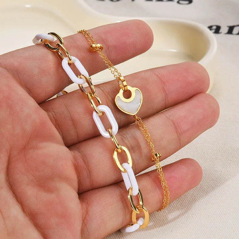 Silver stainless steel bracelet with a double-layer heart pendant featuring dark resin insets