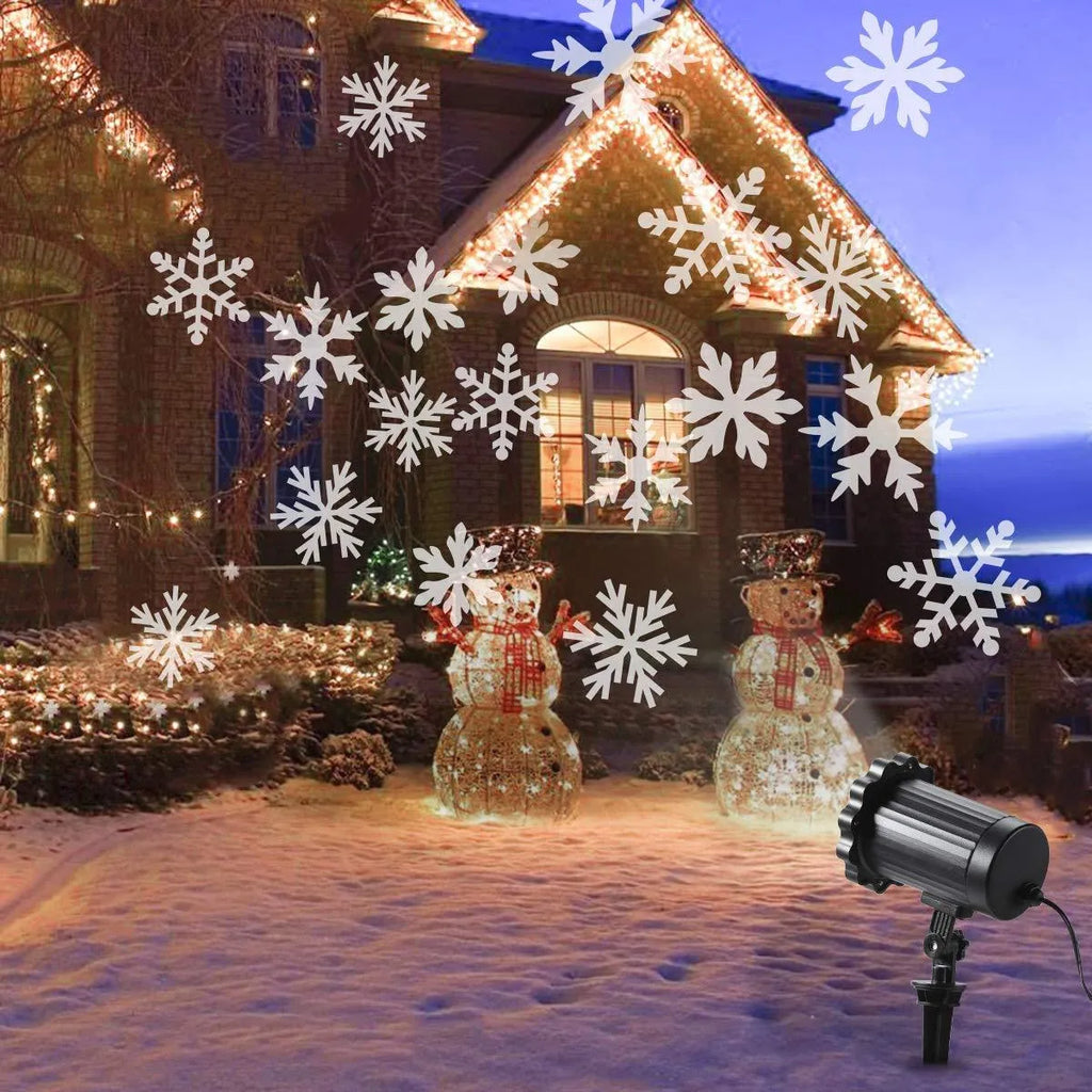 LED Christmas snowflake laser light projector IP65 waterproof with white snowflakes projecting onto a garden wall at night