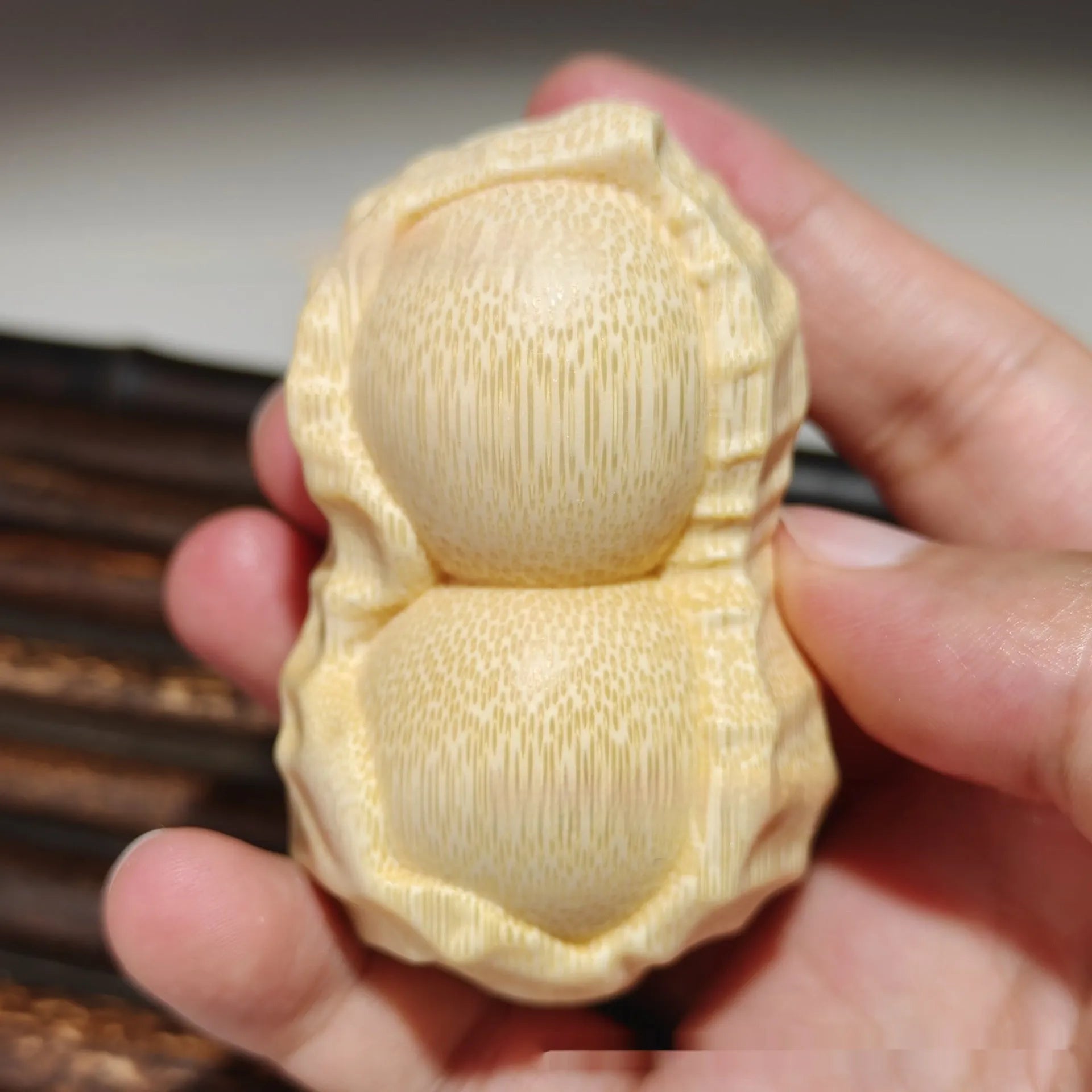 Modern minimalist solid bamboo carving peanut ornament on a neutral background.