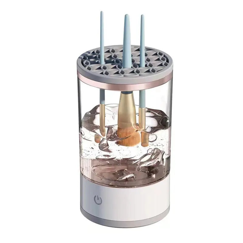 Grey and white electric makeup brush cleaner machine with USB cable on a white background