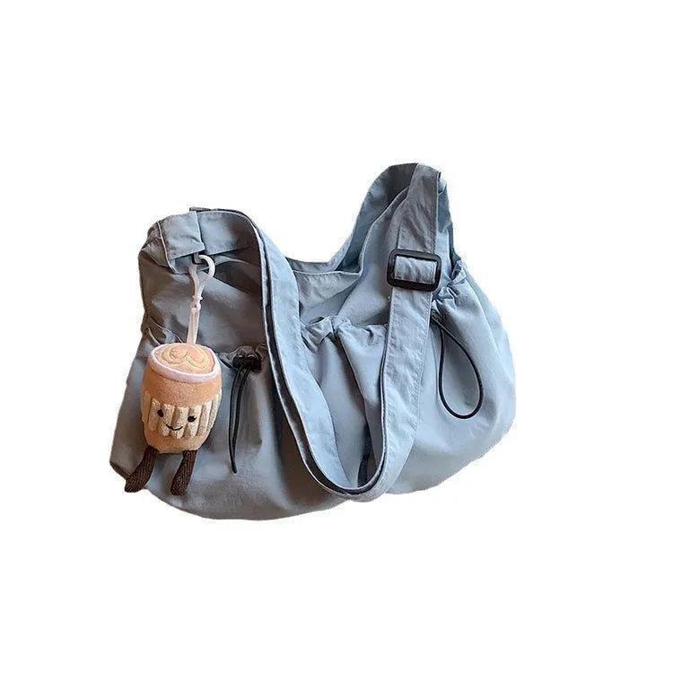 Green pleated polyester crossbody bag showing split pocket design and folding construction