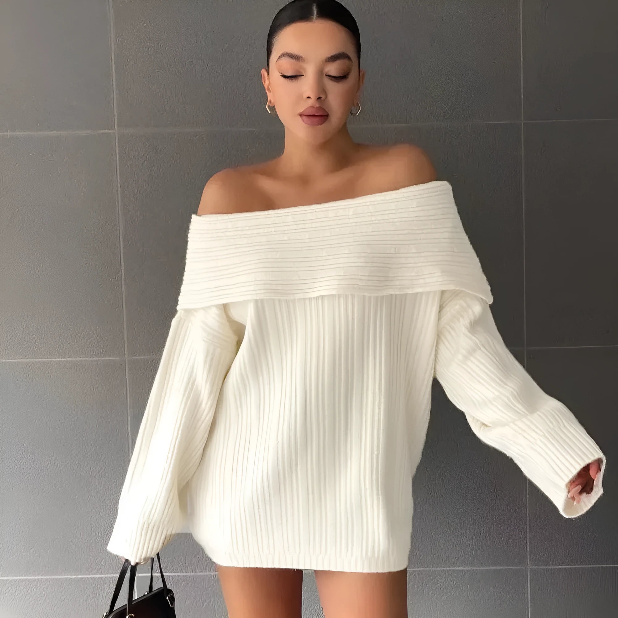 A woman wearing a loose, long-sleeved acrylic pullover sweater in a neutral colour.