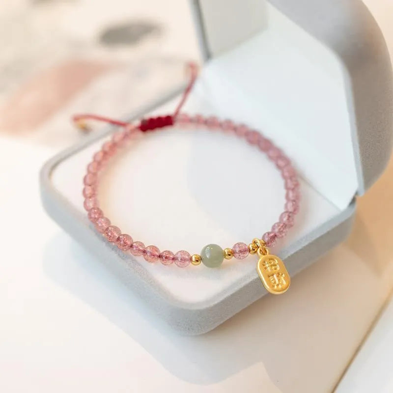 Hand-woven red rope bracelet with strawberry quartz crystal lucky charm