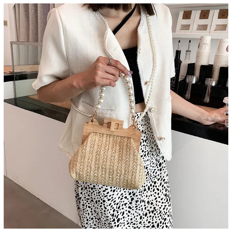 Women's straw woven shoulder bag with pearl chain strap and multiple internal compartments in horizontal square shape