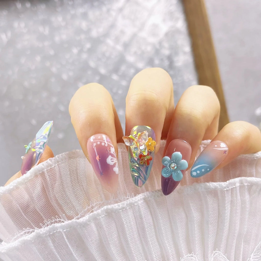 Handmade colourful false nails with 3D embossed flowers and butterflies on almond-shaped nails