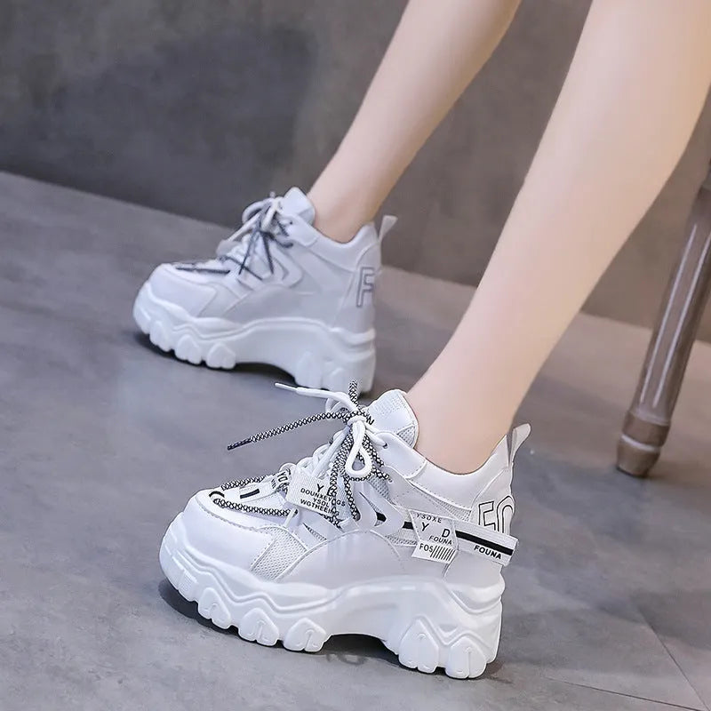 Women's white and black mesh platform sports shoes with cross strap and rubber sole.