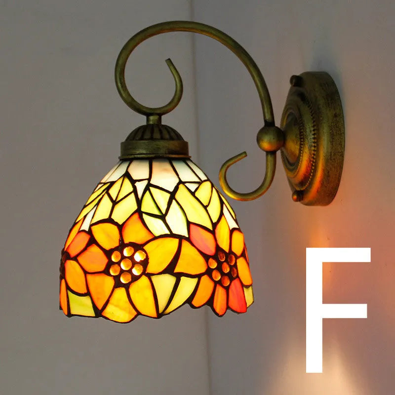 A coloured stained glass wall lamp mounted on a corridor wall, showing one of six available style variants.