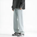 Men's light blue straight leg jeans with button fly waist on a plain background