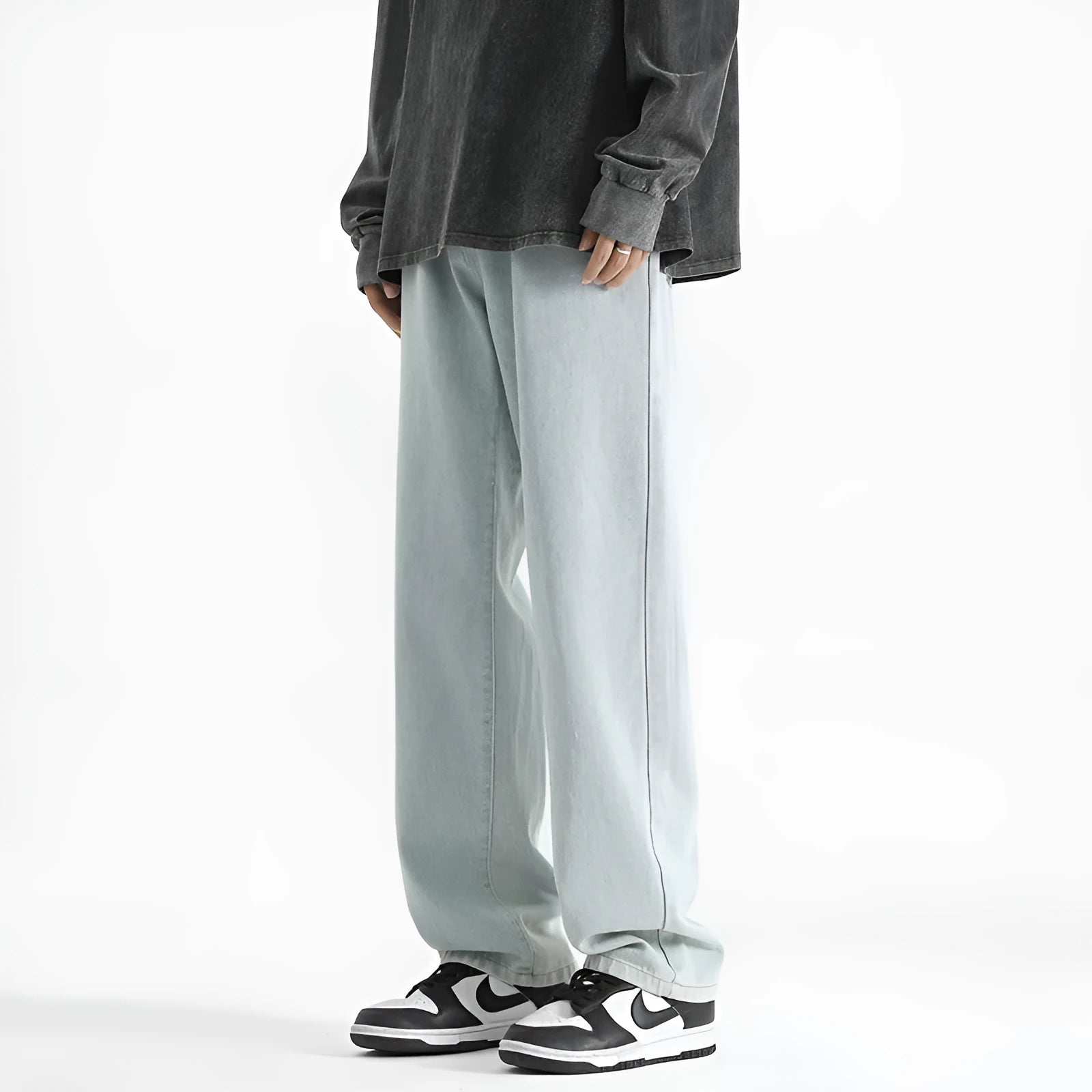 Men's light blue straight leg jeans with button fly waist on a plain background