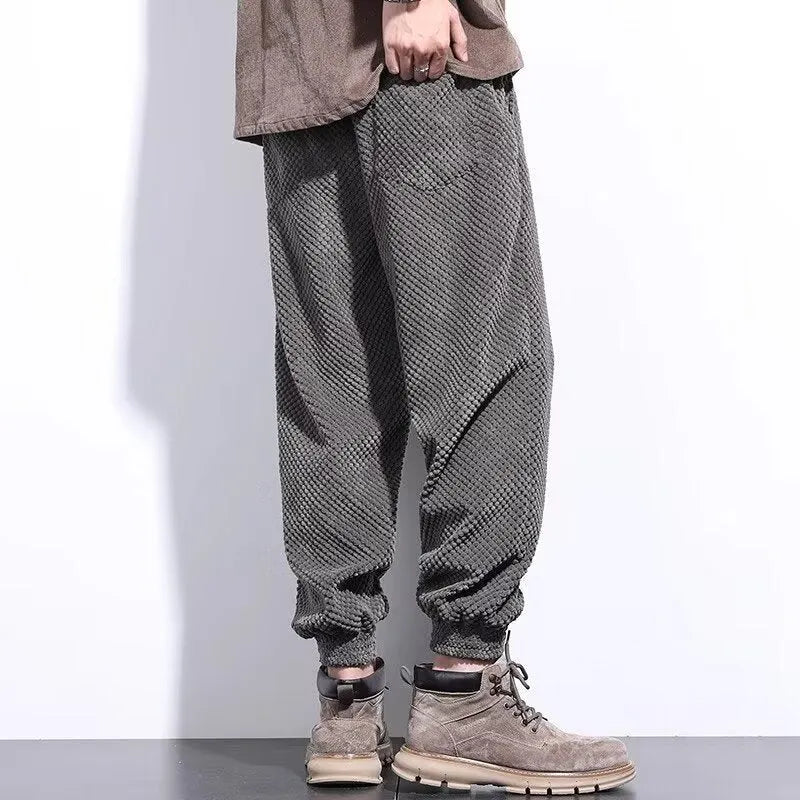 Men's grey ankle-tie sweatpants with a straight leg on a plain background