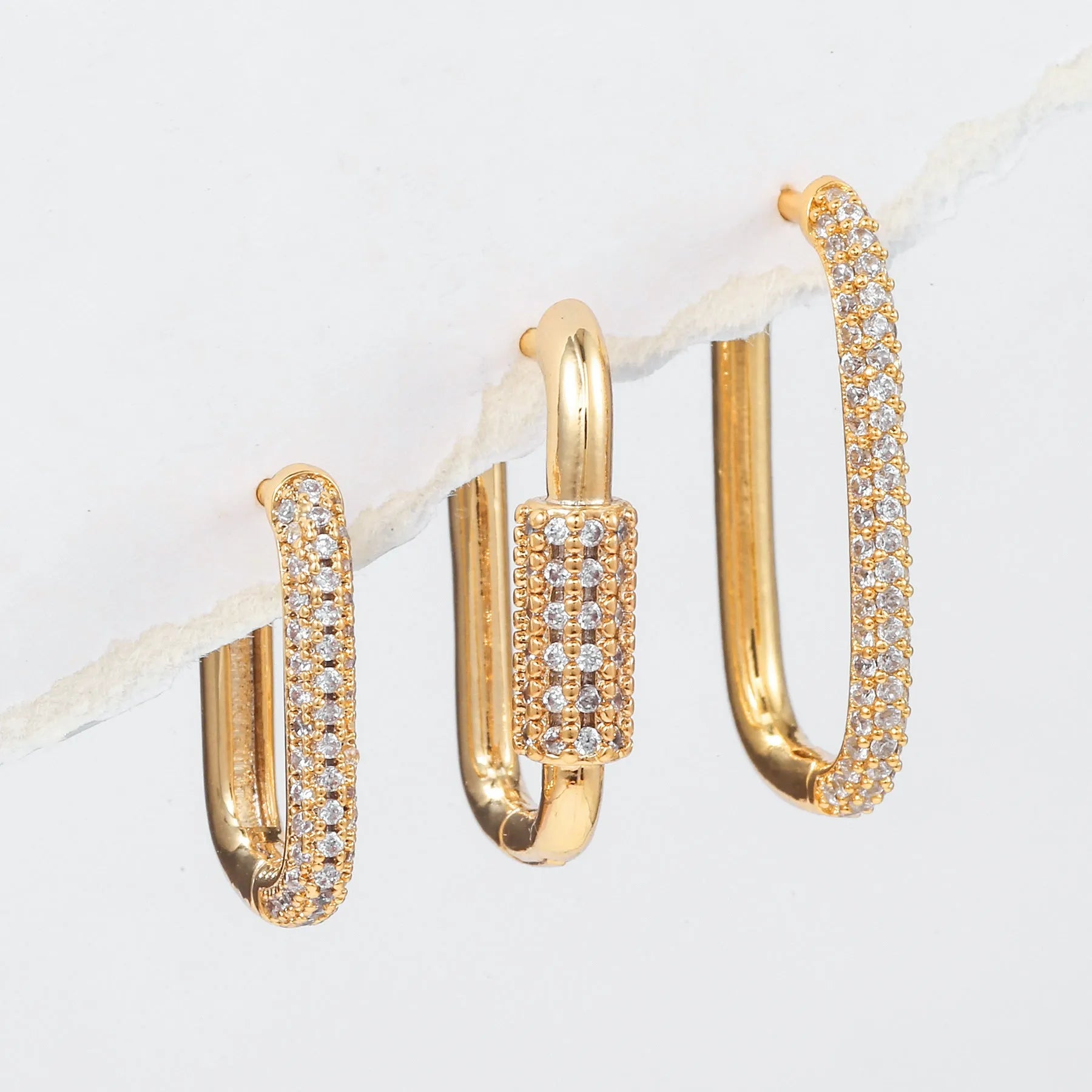 Three geometric copper ear clips with micro inlaid zircon stones in gold and white gold finishes
