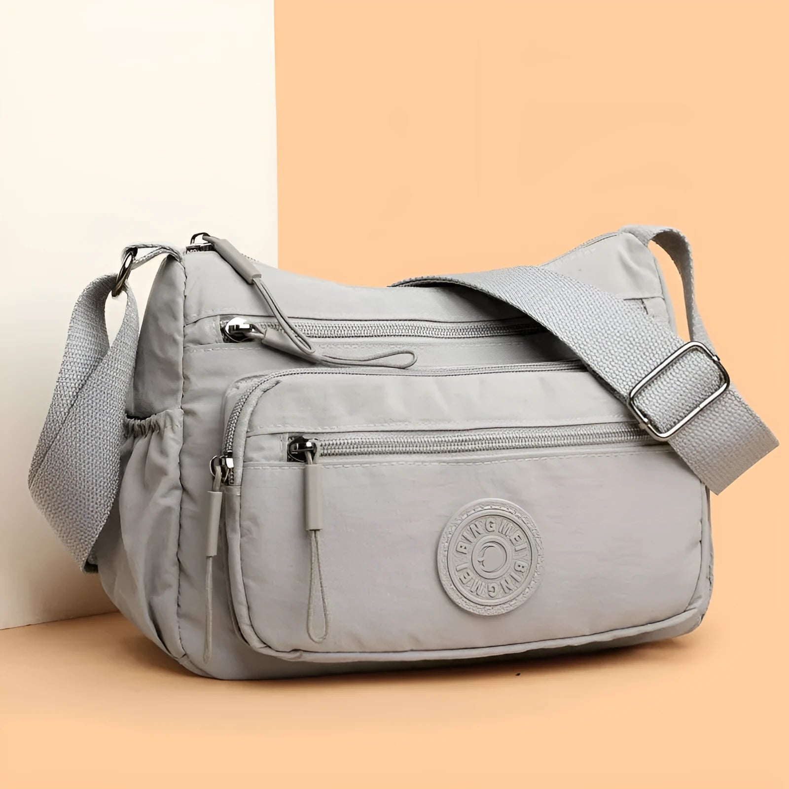 Water-repellent nylon crossbody cloth bag showing internal zipper compartments and shoulder strap
