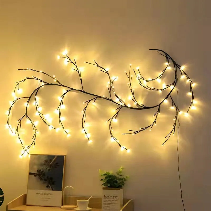 Flexible willow vine Christmas garland with warm white LED lights bent into a decorative shape on a wall.